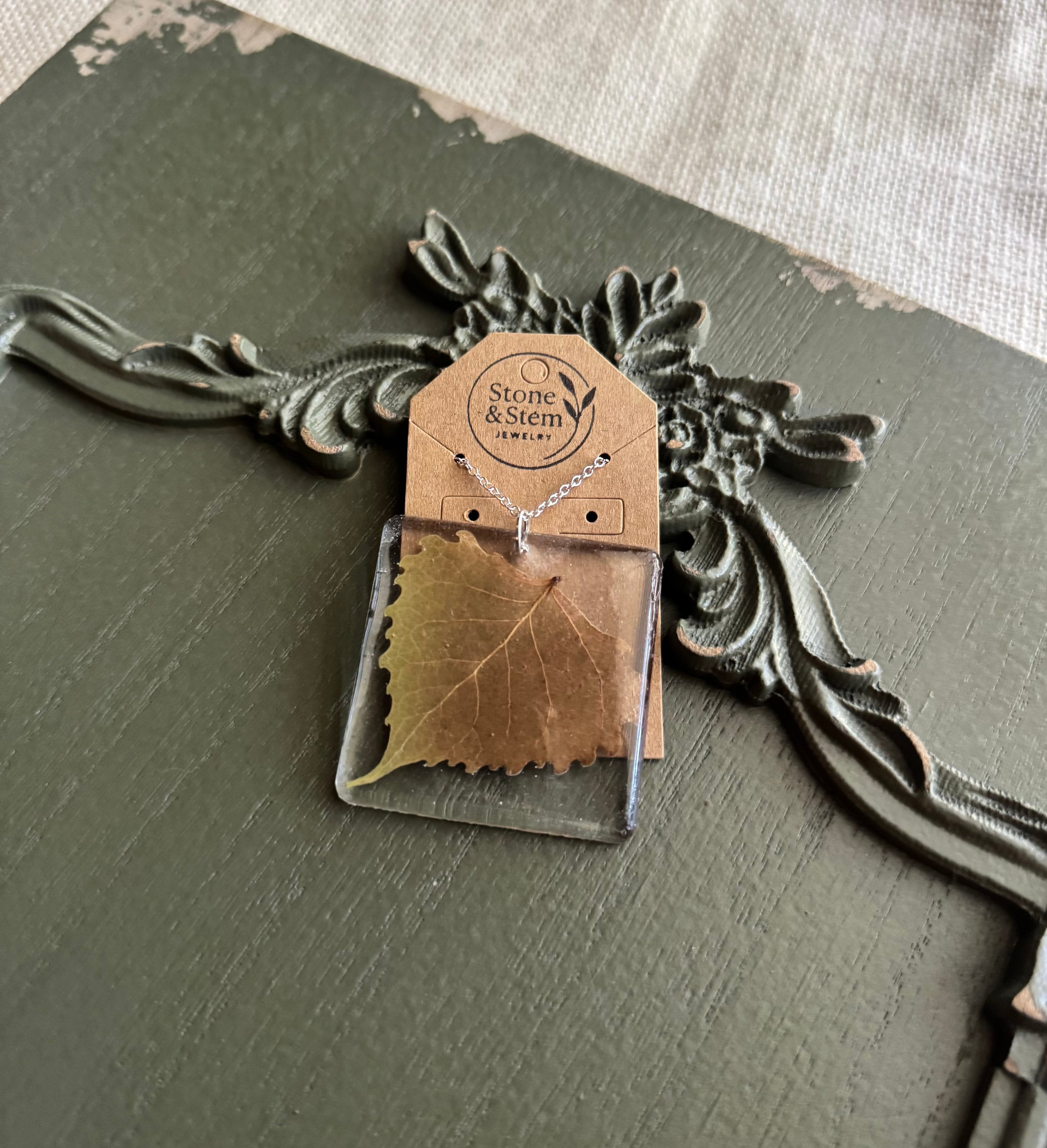 Real leaf preserved in clear rectangular resin pendant necklace on silver-tone chain, displayed on Stone & Stem Jewelry card