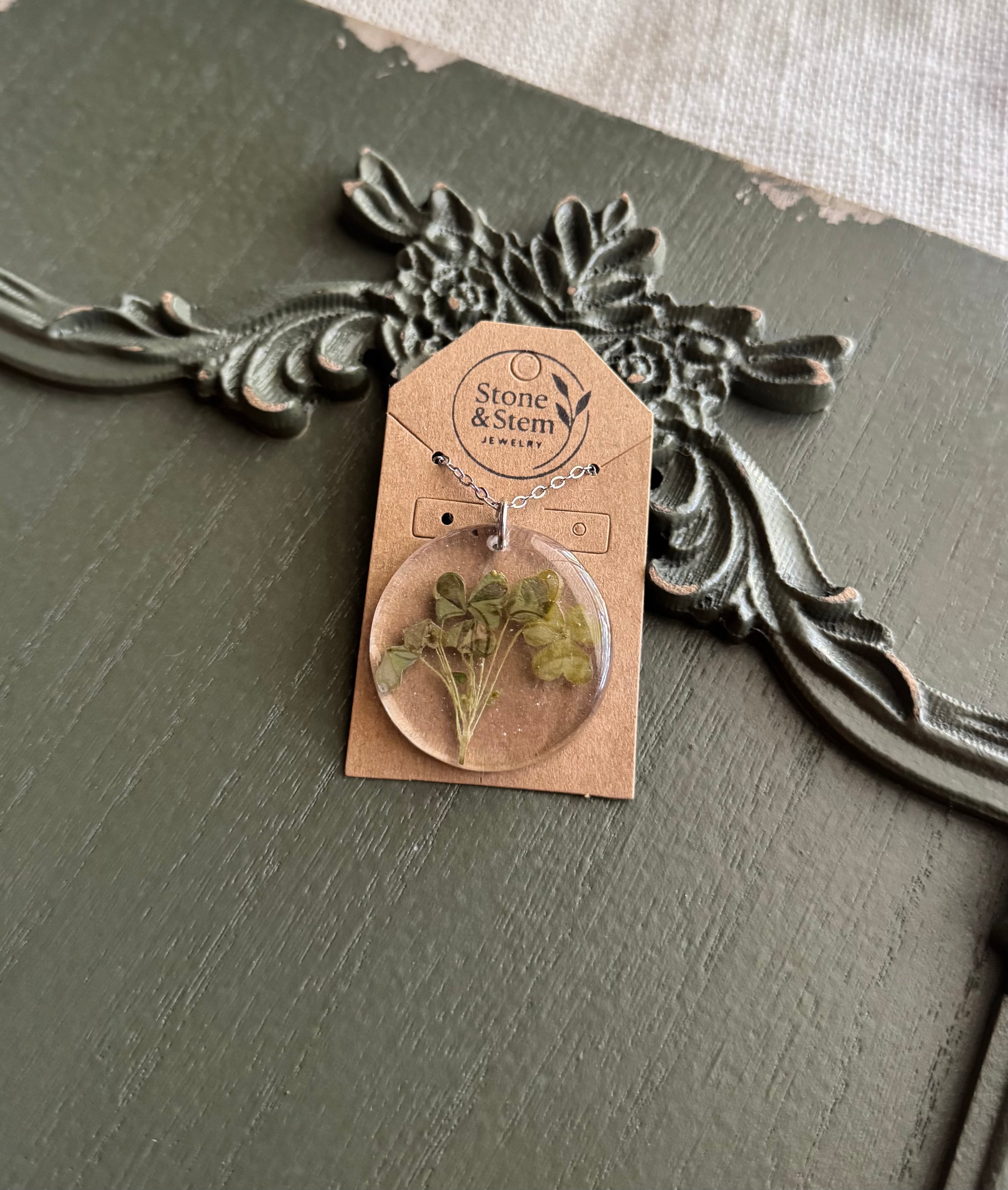 Round clover resin pendant necklace on silver chain displayed on Stone & Stem Jewelry card