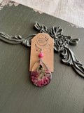 Indian Paintbrush wildflower preserved in clear teardrop resin pendant necklace with pink stone bead on silver-tone chain, displayed on Stone & Stem Jewelry card