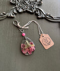 Indian Paintbrush wildflower preserved in clear teardrop resin keychain with pink stone bead and silver-tone lobster clasp, displayed on Stone & Stem Jewelry tag