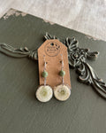 Fluffy white flower resin dangle earrings with sage green stone beads on a kraft paper Stone & Stem Jewelry card