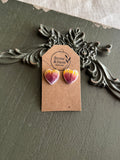 Pair of heart-shaped resin stud earrings with pressed purple and yellow blanket flower petals on a Stone & Stem Jewelry kraft card